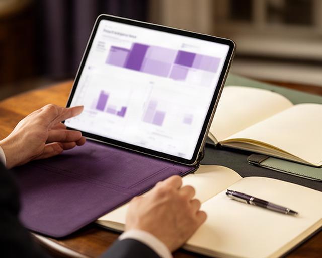 Lector consultando un informe tecnológico premium en una tableta junto a una libreta